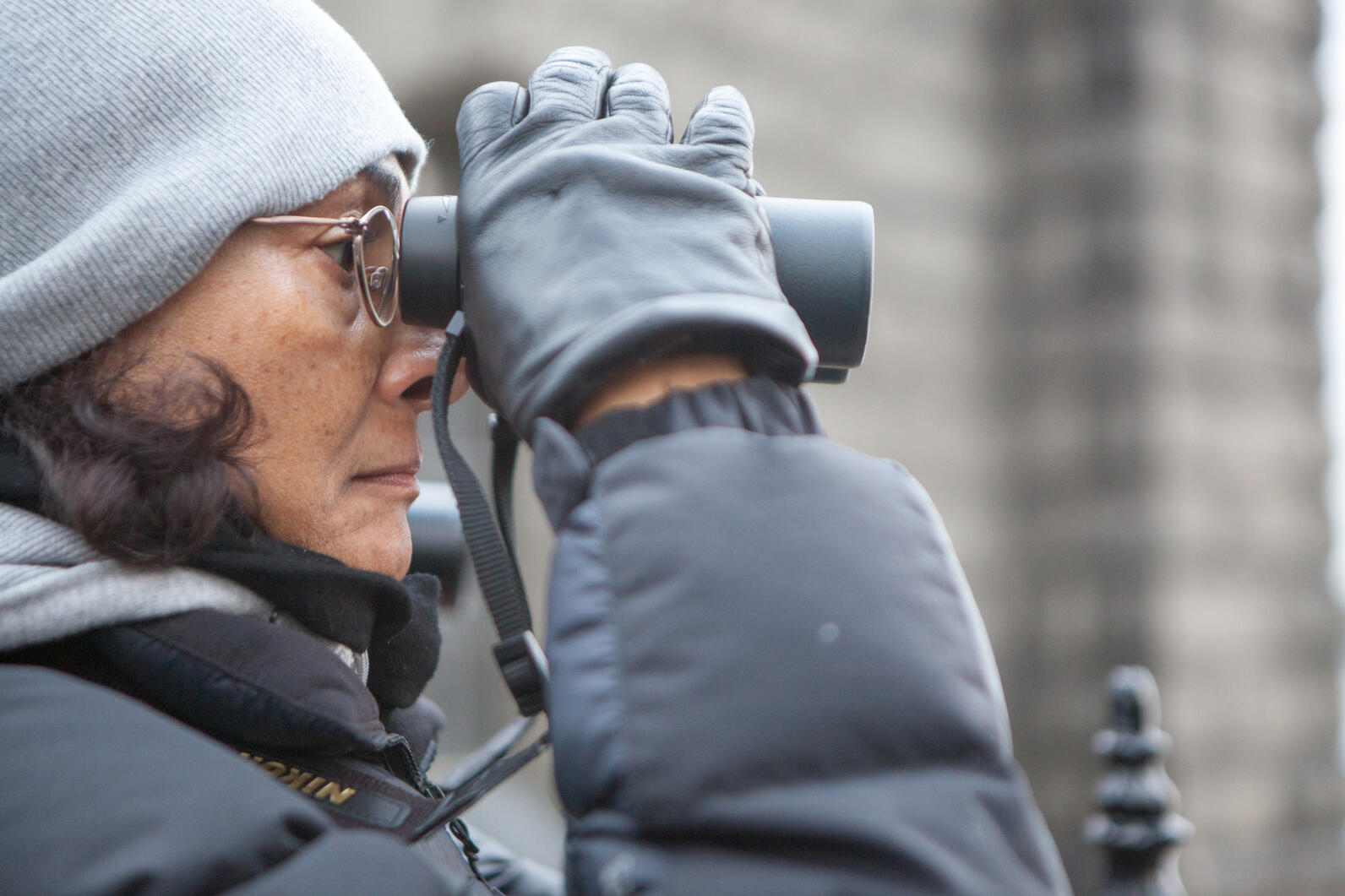 Woman holding and looking through binoculars Woman holding and looking through binoculars