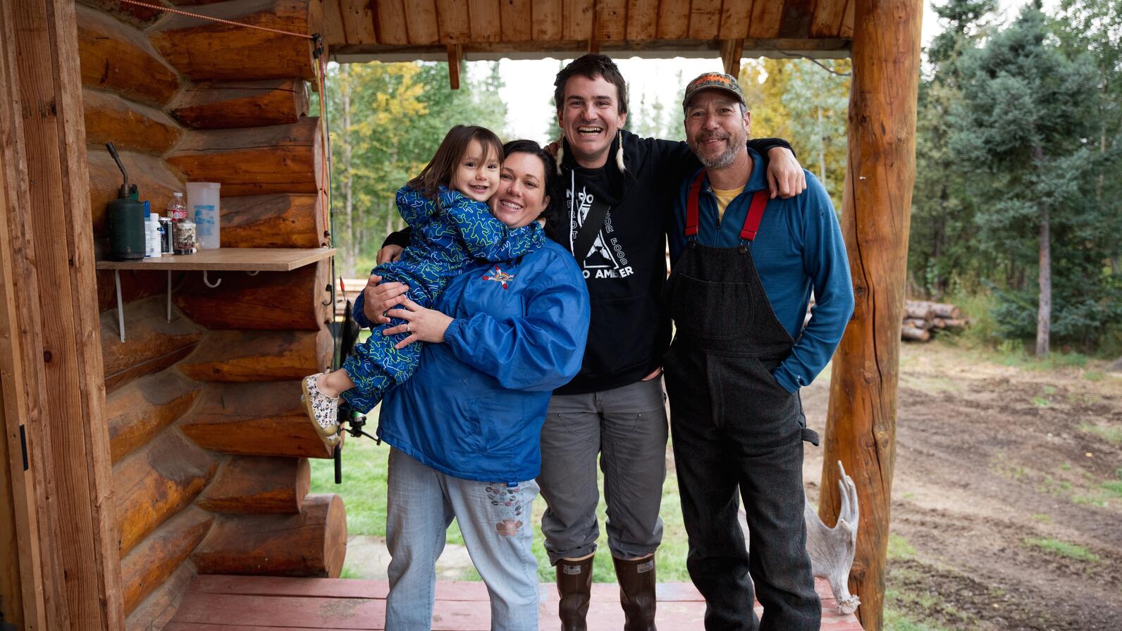 Family standing on cabin porch