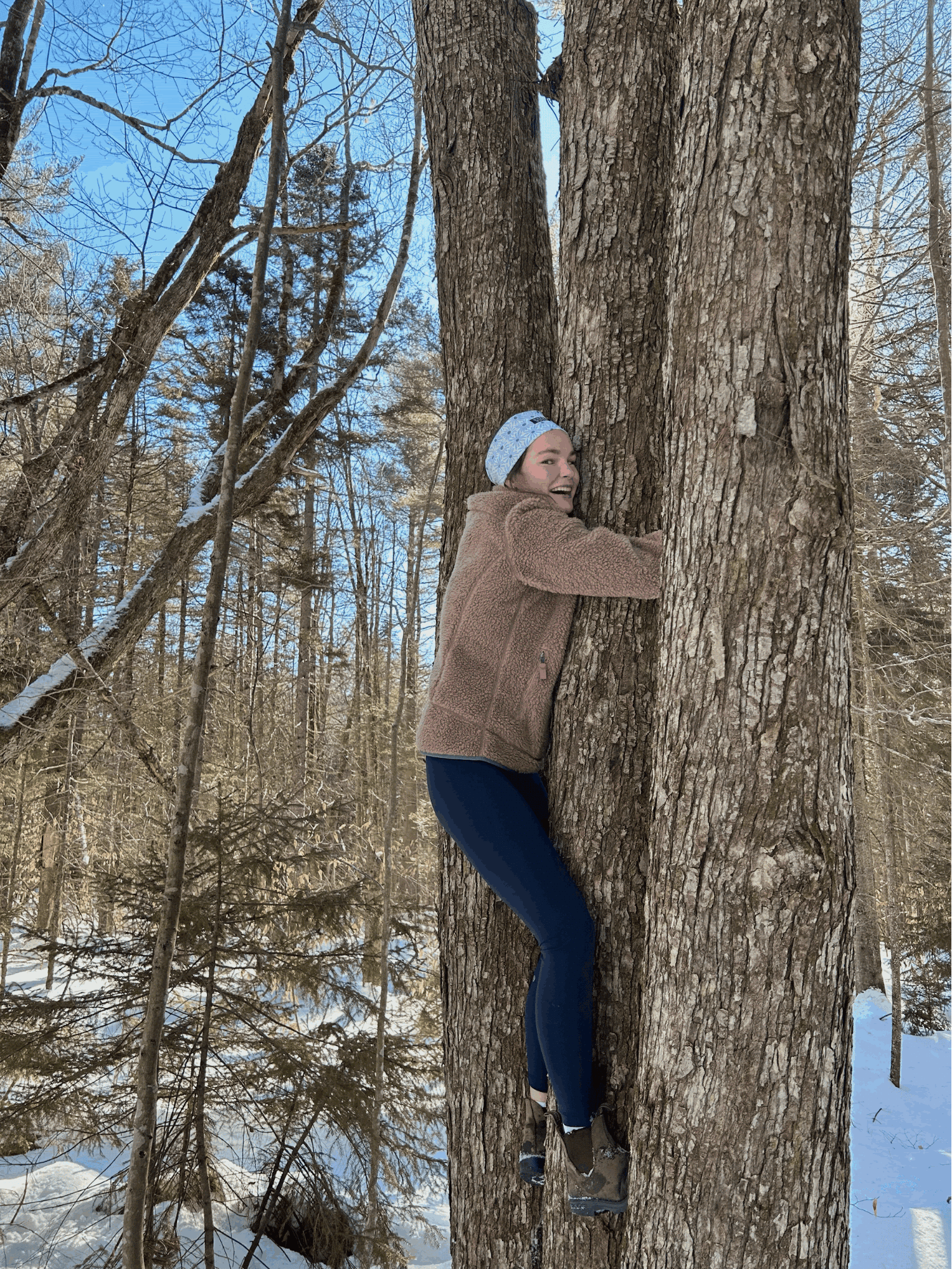 Woman hugging tree in snow