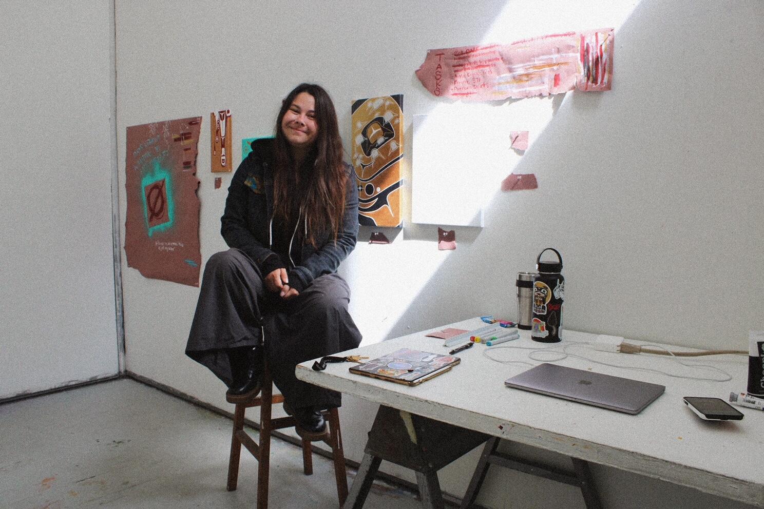 Woman sitting in art studio smiling