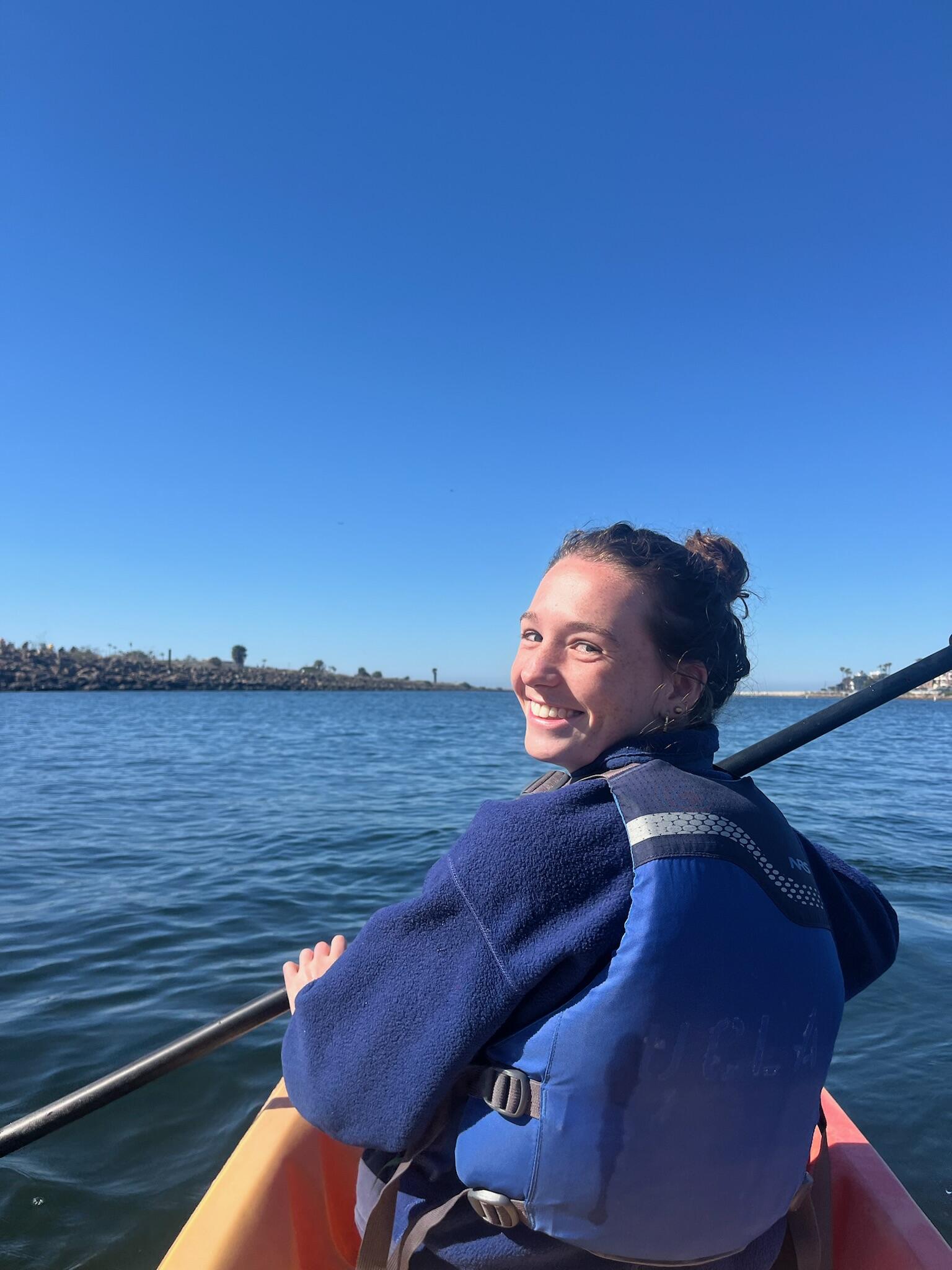 Woman smiling while kayaking on water Woman smiling while kayaking on water
