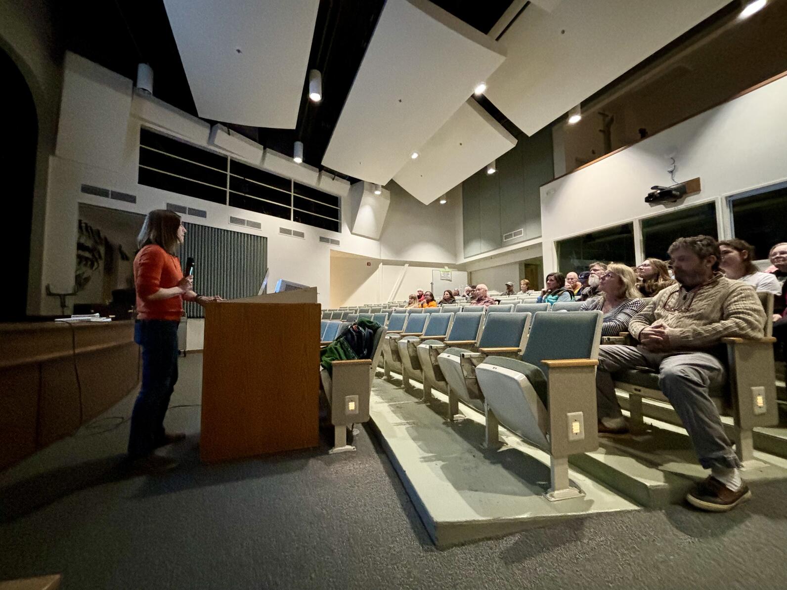 Woman lecturing in auditorium to audience