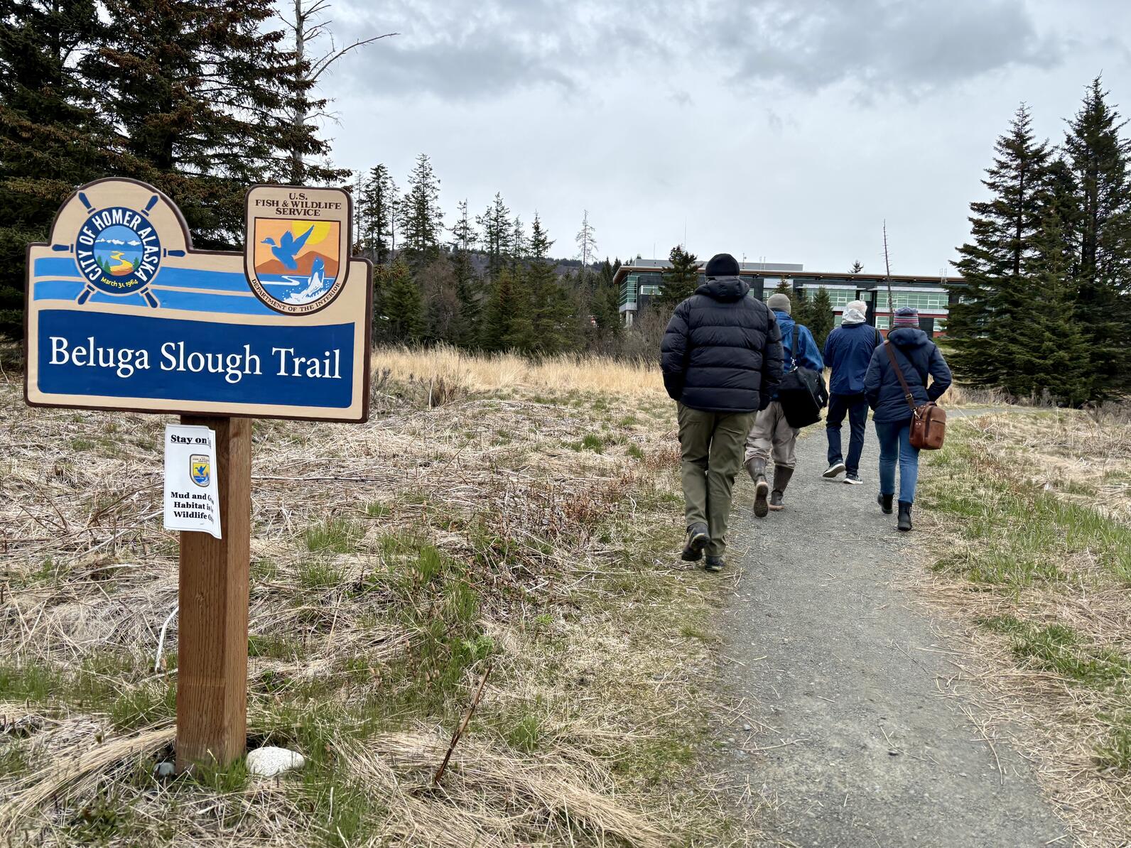 People walking on trail with cloudy skies