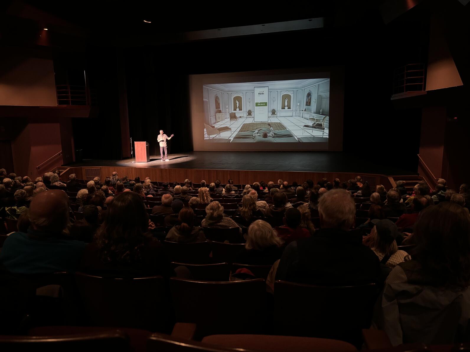 Figure speaking to auditorium audience 