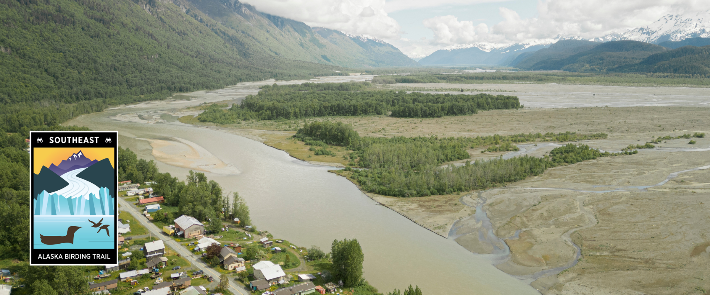 Community in mountain valley next to river confluence